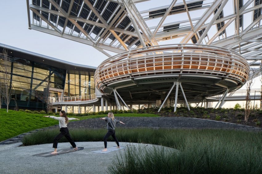 Women in doing yoga in front of structure by Hood Design Studio